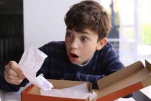 Boy Looking at Pizza Receipt Appears to be Shocked